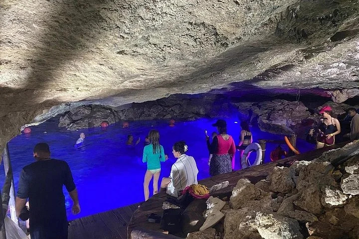 Visitors inside a lit limestone cave